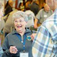 three alumni talk together